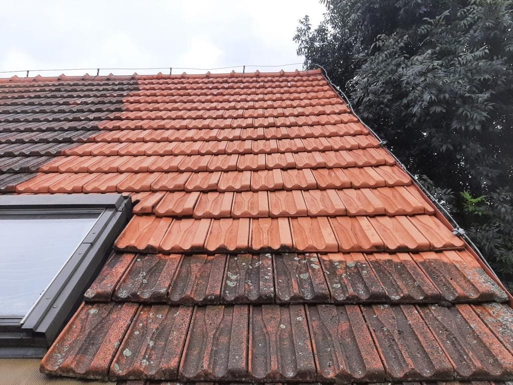 Střešní tašky s viditelným rozdílem mezi očištěnou a znečištěnou částí
