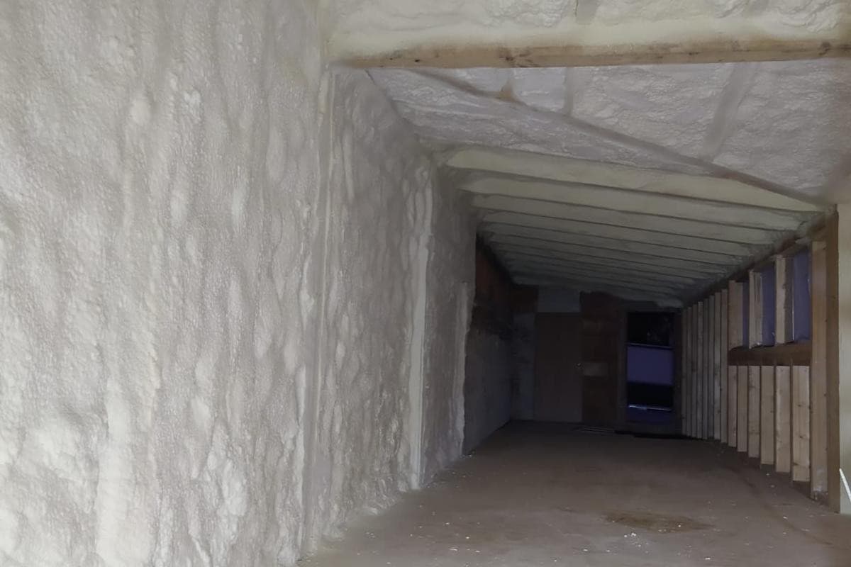 Podkrovní prostor s pěnovou izolací mezi dřevěnými prvky